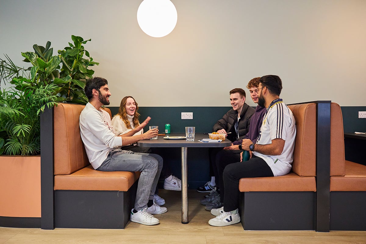Five graduates sat around a table, chatting