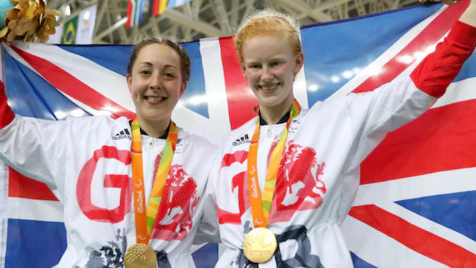 Picture of Sophie with Helen Scott wearing their gold medals holding a Union Jack flag